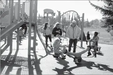  ?? Herald photo by Tim Kalinowski ?? Lakeview students Charlotte and Isabelle Gallant help break in the new equipment at the grand opening of the Lakeview Community playground at Lakeview School on Friday. Grandparen­ts Fran and Brian Roycroft look on.