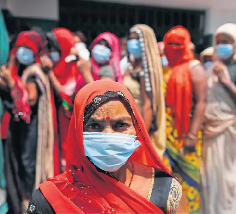  ??  ?? HEALTH CRISIS: A woman waiting in line to vote in elections in India, which a leading virologist has claimed to be a supersprea­der event in a country that has recorded more than 14 million cases and more than 173,000 deaths.