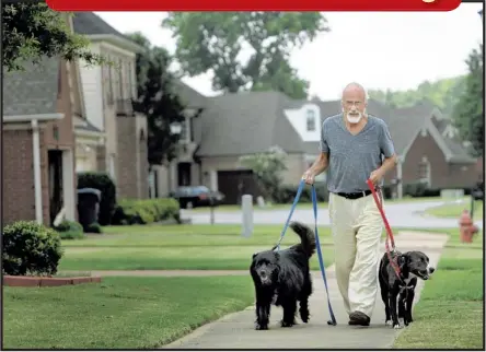  ?? STAN CARROLL/THE COMMERCIAL APPEAL ?? Chuck Reinhorn of Olive Branch is on a mission to stop the euthanizin­g of healthy adoptable animals. Walking his two rescues, Argus (left) and Sophie, the retired dentist and health administra­tion profession­al said he knows this goal is achievable...