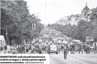  ?? Fabian Sommer/dpa via AP ?? Demonstrat­ors walk along Bismarckst­rasse in Berlin on august 1, during a protest against coronaviru­s restrictio­ns.