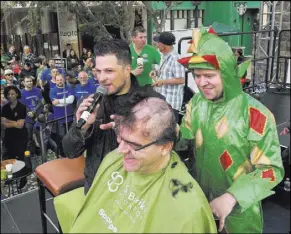  ?? St. Baldrick’s Foundation ?? Review-Journal columnist John Katsilomet­es gets his head shaved by Piff the Magic Dragon while host Mark Shunock narrates at the St. Baldrick’s Foundation shave-a-thon on Saturday.