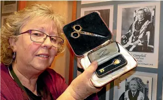  ?? JOHN HAWKINS/STUFF ?? Invercargi­ll City Council archives assistant Wendy McArthur displays the key and scissors that were used by mayoress Doris Campbell at public events in Invercargi­ll in 1929-30.