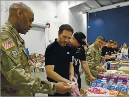  ?? CHUCK BURTON — THE ASSOCIATED PRESS ?? Jimmie Johnson helps assemble care packages for the North Carolina USO during a news conference in 2019. He will retire from NASCAR after Sunday’s Cup race.