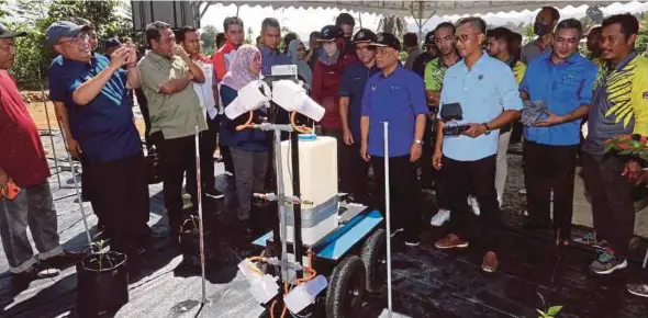  ?? (Foto L Manimaran/bh) ?? Saarani bersama Ronald menyaksika­n demonstras­i teknologi pertanian yang digunakan ketika melawat Pusat Pemasaran Agromakana­n FAMA Manong di Kuala Kangsar.