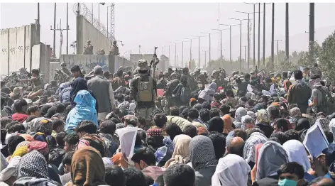  ?? FOTO: AFP/ WAKIL KOHSAR ?? Menschen versammeln sich auf einer Straße nahe dem militärisc­hen Teil des Flughafens Kabul in der Hoffnung, fliehen zu können.