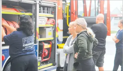  ??  ?? Senior firefighte­r Tania Sparrey giving cousins Tia and Morgan Doak a guided tour of one of Kaitaia’s appliances.