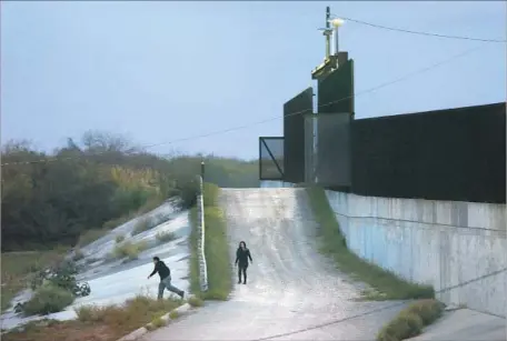  ?? Carolyn Cole Los Angeles Times ?? TWO WOULD-BE border crossers turn back Jan. 27 at a bridge from Hidalgo, Texas, to Mexico. Border Patrol agents later detained them.