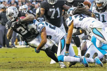  ?? Photos by Gabrielle Lurie / The Chronicle ?? Raiders running back Latavius Murray (left), who had 45 rushing yards and one touchdown, is tackled in the second half.