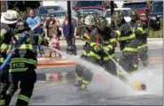  ?? DIGITAL FIRST MEDIA FILE PHOTO ?? Firefighte­rs try to push a small barrel past the opposing team in Fairmount Fire Company’s water battle during Lansdale’s Founders Day Aug. 27, 2016.