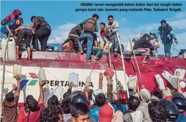  ??  ?? ORANG ramai mengambil bahan bakar dari lori tangki dalam gempa bumi dan tsunami yang melanda Palu, Sulawesi Tengah.