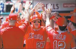  ?? Danny Moloshok The Associated Press ?? Los Angeles Angels outfielder Mike Trout is congratula­ted by teammates after hitting a grand slam off Detroit Tigers starter Rick Porcello in an April 2013 game in Anaheim, California. MLB is working on a plan with players to get the season started.