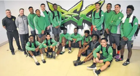  ?? NIKKI SULLIVAN/CAPE BRETON POST ?? St. Patrick’s High School basketball team (The Irish) pose for a photo near the “BEC” graffiti tag inside the Breton Education Centre cafeteria on Feb. 6. The team from Ottawa, Ont., came down to compete in the Coal Bowl Classic 2019 after having hosted the BEC boys basketball team for a tournament in Ottawa in the fall. The players have a close connection that can be seen on and off the court and it might be due to how multi-cultural the team is. Shown here are, front row from left, Ricardo Sylvestre, Ben Garcia, Josh Rutarindwa, Armand Malumalu, Patrick Johnson, Frantzini Cambronne, Andrew Bui, back row from left, Ed MacPherson (coach), Matt Koeslag (coach), Precieux King, Ngatangwe Katijaani, Matthew Kendall, Chrys Kazadi, Albert Openia, James Merina, Adam Eslava and Sam Saint-Val.