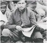  ??  ?? A white man reads a book while seated on the shoulders of a black girl