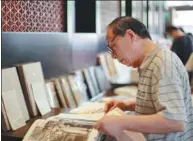  ?? PROVIDED TO CHINA DAILY DENG RUI / CHINA DAILY ?? Top: An aerial view of the compound of Anderson Firm which has been renovated into a memorial site. Above: A visitor flips through a book on the history of the Qing Dynasty (1644-1911) at the site.