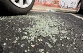  ?? Scott Strazzante / The Chronicle ?? Broken glass from a car window litters Illinois Street north of 22nd Street.