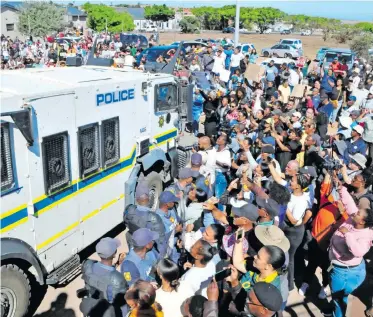  ?? | PATRICK LOUW Independen­t Newspapers ?? A CROWD expresses anger after Jacquen Appolis, Steven van Rhyn, Raquel Chantel Smith and Phumza Sigaqa appeared in the Vredenburg Magistrate’s Court after being accused of the traffickin­g of Joshlin Smith.