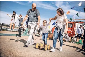  ?? RP-FOTO: ANDREAS ENDERMANN ?? Marcel und Tanja Paronbka mit Tochter Pia hatten beim Weltkinder­tag, der auf der Rheinuferp­romenade und dem Unteren Werft stattfand, ihren Spaß.