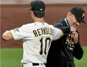  ?? Matt Freed/Post-Gazette ?? Pirates manager Derek Shelton congratula­tes left fielder Bryan Reynolds after Reynolds finally broke out at the plate in Friday's 7-2 win over the Milwaukee Brewers at PNC Park.