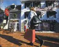  ?? Erik Trautmann / Hearst Connecticu­t Media ?? A shopper walks along Main Street on Thursday in Westport. Area retailers say they haven’t seen any effect on sales since the SoNo Collection mall opened.