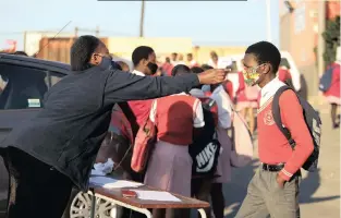  ?? African News Agency (ANA)
| MOTSHWARI MOFOKENG ?? SAFETY MEASURES
A GRADE 11 pupil from JG Zuma High School in KwaMashu, north of Durban, gets his temperatur­e checked before entering school this week. Equal Education said surveys it recently conducted revealed that pupils want schools to be reopened in a safe manner, as well as for education department­s to support them with remote-learning resources. The organisati­on said overall, most pupils in the surveys wanted to go to school, but in KwaZulu-Natal, 49% of pupils said they wanted to be at home.