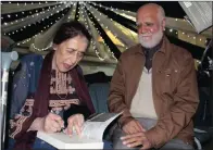  ??  ?? Rabia Motala or ‘Aunty Choti’, said to be the strength behind her husband, Dr Chota Motala, signs a book for relative Abbas Sardiwalla.