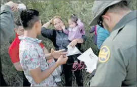  ?? JOHN MOORE Getty Images ?? ASYLUM SEEKERS prepare to be taken into custody. Children 4 and younger aren’t separated from their parents but that may change, a border official says.