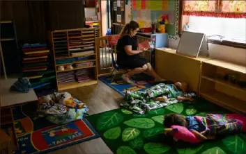  ?? Jeff Swensen/For The Washington Post ?? Chelsea Hallinan, 37, organizes children's take-home packets while they nap at the Begin With Us Pre-K Center in Altoona in 2021.