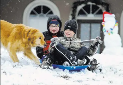  ?? Paula Merritt ?? The Meridian Star Gavin Joyner, left, and Payton Harrell, both 9, enjoy a sleigh ride Friday with Ella the dog after snow fell in Collinsvil­le, Miss.