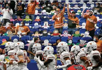  ?? Kin Man Hui / Staff photograph­er ?? The Texas Longhorns run onto the field for the 2020 Valero Alamo Bowl at the Alamodome. More than a dozen spectators repeatedly refused to wear their masks properly, according to city enforcemen­t data.