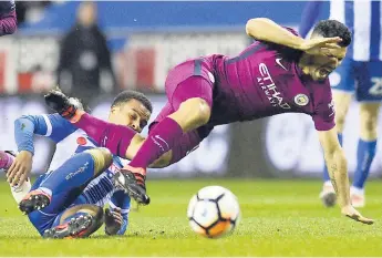  ??  ?? ENTRADA. Nathan Byrne, del Wigan, derriba al delantero del Mánchester City, Sergio Agüero.