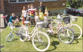  ?? (NWA Democrat-Gazette/Susan Holland) ?? People stand near some of the bicycles given away Sept. 9 at the Sulphur Springs Public Library birthday celebratio­n.
