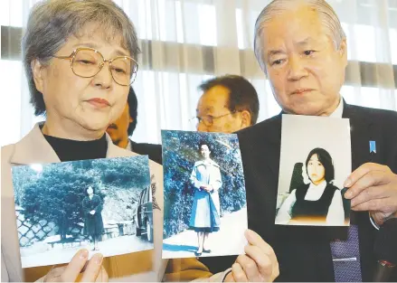  ?? AFP / AFP / Gett y Imag es files ?? Shigeru, right, and Sakie Yokota, parents of Megumi Yokota, who was abducted to North Korean in 1977,
shown here in 2004 with portraits of their daughter brought back by Japanese delegates.