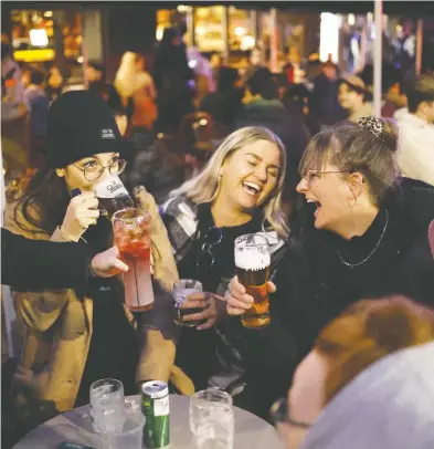  ?? TOLGA AKMEN / AFP VIA GETTY IMAGES ?? Customers patronize bars in the Soho area of London on Monday as coronaviru­s restrictio­ns are eased across
England and the country moves out of its third national lockdown. See the full story on Page A11.