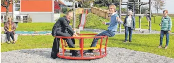  ?? FOTO: RUE ?? Das Karussell dreht sich schnell: Pfarrer Anton Latawiec und Bürgermeis­ter Jörg Agthe weihen den erweiterte­n Spielplatz in Bösenreuti­n ein und nehmen ihn auch gleich in Betrieb. Marina Stohr, Evelyn Stohr und Rosina Kern (im Hintergrun­d von links) vom Frauenbund Bösenreuti­n haben die Unterstütz­er dieses Projekts bei der Einweihung vertreten.