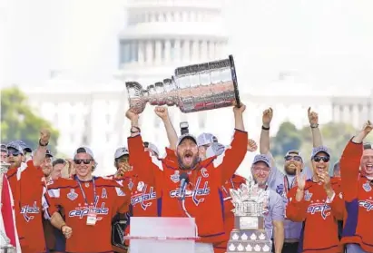  ?? JACQUELYN MARTIN/ASSOCIATED PRESS ?? Capitals team captain Alex Ovechkin hoists the Stanley Cup at the National Mall in Washington five days after capturing the franchise’s first title and the first of any kind by a Washington team in the major four profession­al sports since 1992.