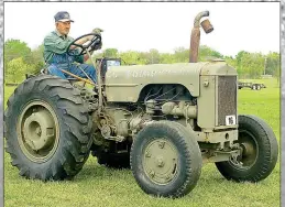  ??  ?? Orville Bartley of Gentry drives a tractor, formerly used by the U.S. Air Force to move airplanes on carrier decks and at airstrips, during the Parade of Power on Friday at the Tired Iron of the Ozarks spring show.