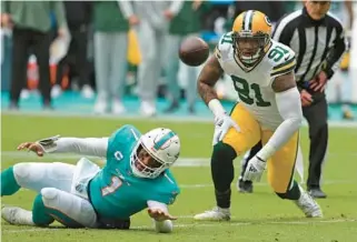  ?? JOHN MCCALL/ SOUTH FLORIDA SUN SENTINEL ?? Dolphins quarterbac­k Tua Tagovailoa loses the ball after being hit by Packers linebacker Preston Smith at Hard Rock Stadium on Dec. 25 in Miami Gardens.