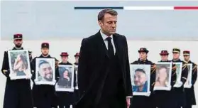  ?? Foto: AFP ?? Emmanuel Macron geht an den Mitglieder­n der Republikan­ischen Garde vorbei, die Porträts der 42 Franzosen und Französinn­en hochhalten, die beim Terrorangr­iff der Hamas am 7. Oktober getötet wurden.