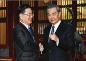  ?? KENZABURO FUKUHARA / ASSOCIATED PRESS ?? South Korean national security director Chung Eui-yong (left) shakes hands with Chinese Foreign Minister Wang Yi before their meeting in Beijing on Monday. Chung said the situation on the Korean Peninsula had “undergone very positive changes.”
