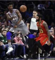  ?? MATT SLOCUM — THE ASSOCIATED PRESS ?? The 76ers’ Jimmy Butler, left, passes the ball as Atlanta Hawks’ forward and former Saint Joseph’s star DeAndre’ Bembry defends in the first half of the Hawks’ 123-121 victory over the 76ers Friday night.