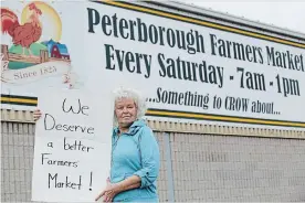  ?? CLIFFORD SKARSTEDT/EXAMINER ?? Ruth Bishop displays her protest sign on Friday outside the Peterborou­gh Farmers' Market at the Morrow Building in Peterborou­gh. She was part of a protest at the market Saturday.