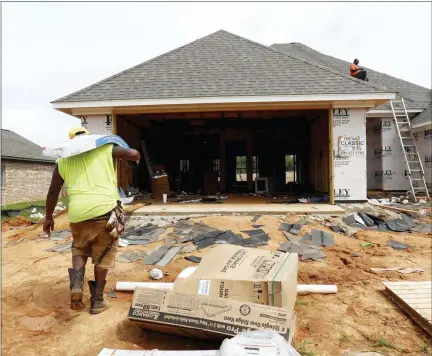  ?? ROGELIO V. SOLIS — THE ASSOCIATED PRESS FILE ?? A worker carries shingles for a roof of a house under constructi­on in a Brandon, Miss., neighborho­od.