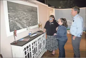  ??  ?? Rome Area History Center Director Selena Tilly (from left), shows off a 1956 aerial map of downtown Rome to planners Brittany Griffin and Brice Wood as part of a special Historic Preservati­on Month exhibit.