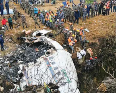  ?? (AFP) ?? Rescuers pull the body of a victim who died in a Yeti Airlines plane crash in Pokhara on Monday.
