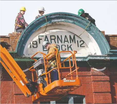  ?? GREG PENDER FILES ?? A demolition crew removes the cement-slab sign from the Farnam Block atop Lydia’s Pub on March 13, 2015.