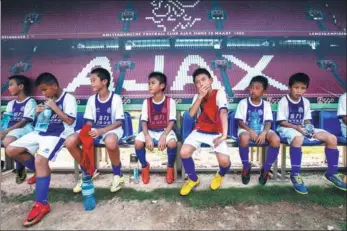  ?? JOHANNES EISELE / AFP ?? Above: Budding young soccer players take a breather during a September training session at Guangzhou R&amp;F Football Academy in Meizhou, Guangdong province. Right: Kids are put through their paces at the school, which is co-run by Dutch giant Ajax.