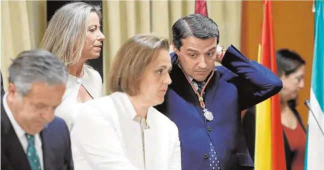  ?? VALERIO MERINO ?? Bellido se ajusta la medalla de capitular, junto a Blanca Torrent y Salvador Fuentes, ante la mirada de Isabel Albás