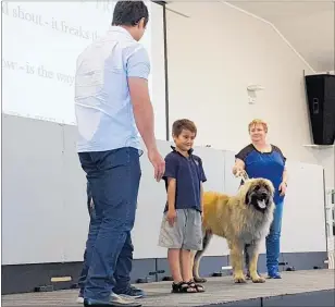  ?? Photo / Laurilee McMichael ?? Jack Horotini of Hilltop School practises standing like a tree around dogs. At left is vet Stacey Tremain and at right is Verna Jensen with her 18-month-old Leonberger dog Shrek.