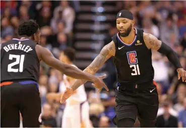  ?? — AFP ?? LA Clippers Marcus Morris Sr. (right) high fives Patrick Beverley after scoring against the Phoenix Suns during the second half of the NBA game at Talking Stick Resort Arena in Phoenix, Arizona, on February 26.