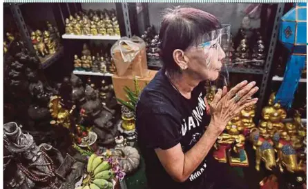  ?? AFP PIC ?? Wanchai Pongsompet­ch praying to her huge collection of Golden Son dolls at her home in Bangkok, Thailand earlier this week.